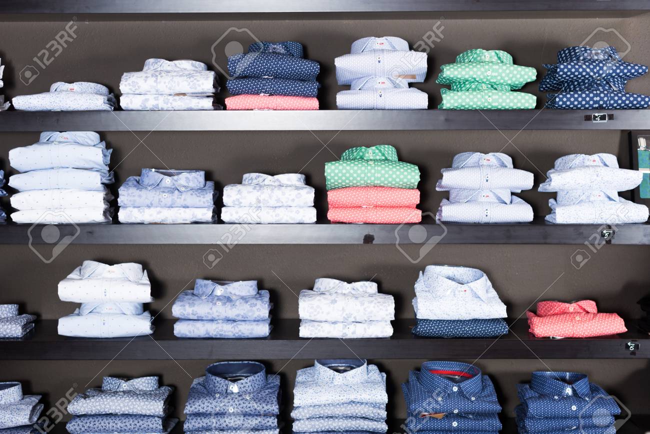 Muchas Camisas De Algodón En Estanterías En La Tienda De Ropa De Los Hombres Fotos, Retratos, Y Fotografía De Archivo Libres De Derecho. 80051961.