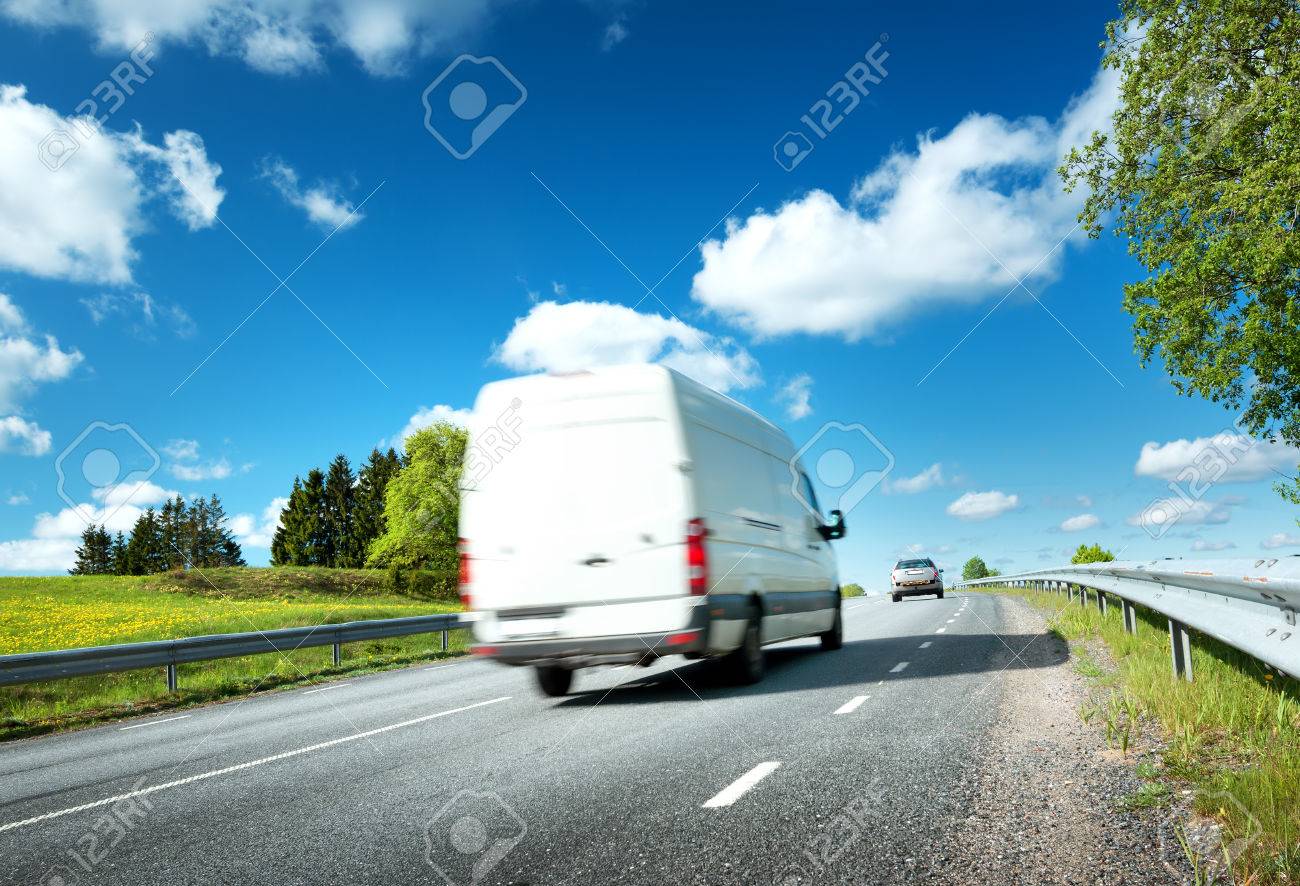 asphalt road on dandelion field with a small truck. van moving on sunny day - 66130881 asphalt road on dandelion field with a small truck. van moving on sunny day - 66130881