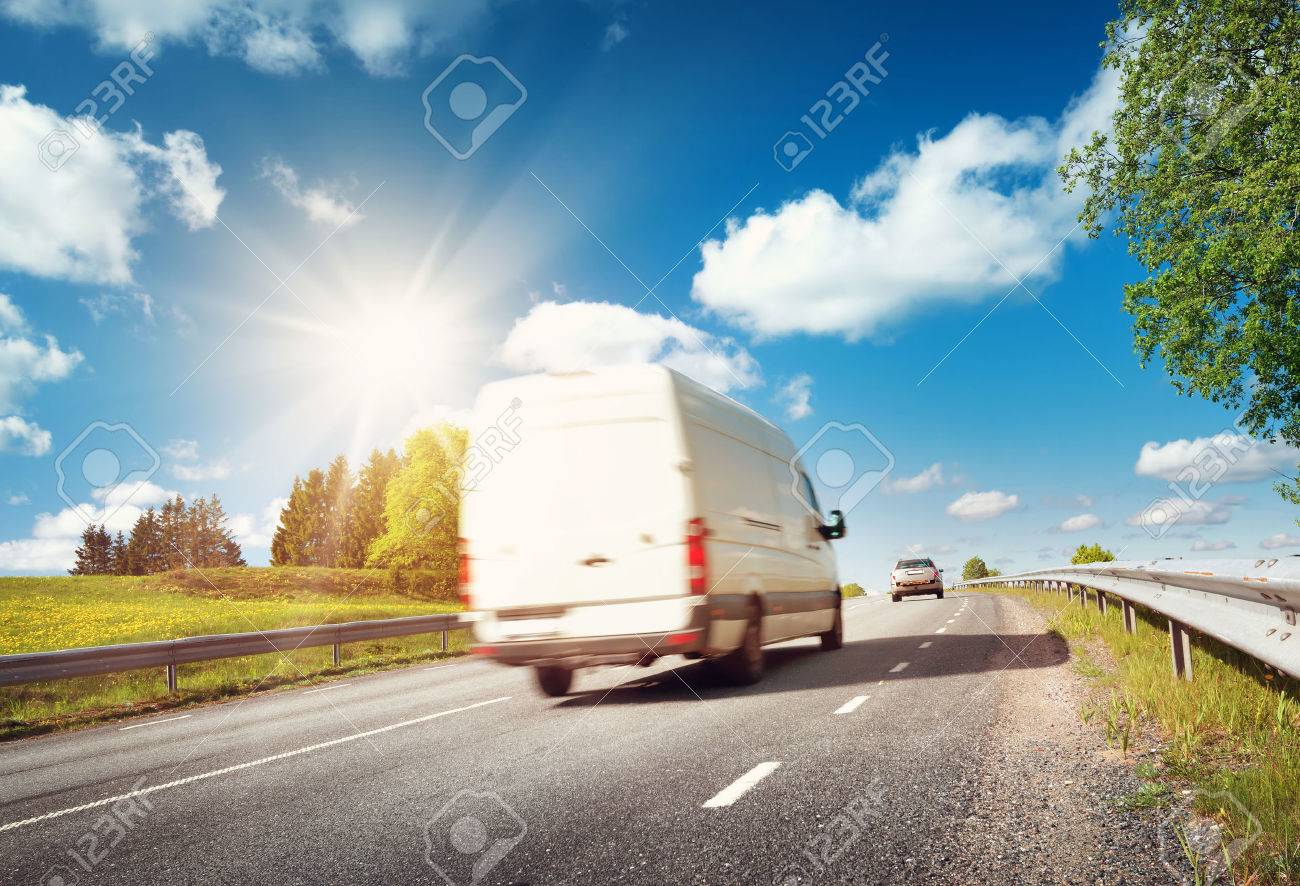 asphalt road on dandelion field with a small truck. van moving on sunny day - 66130870 asphalt road on dandelion field with a small truck. van moving on sunny day - 66130870