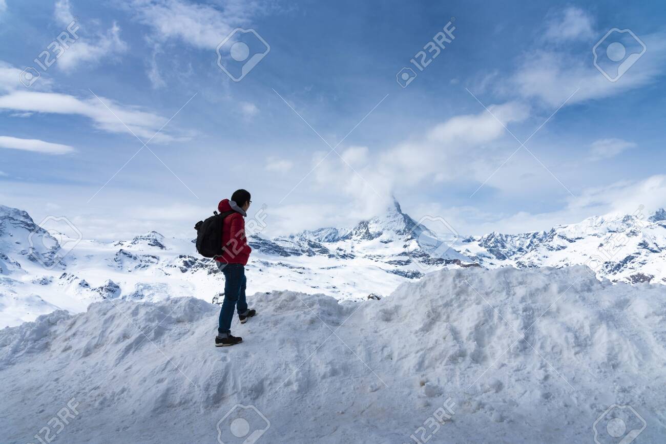Man in red jacket is looking Matterhorn peak on Gornergrat peak, Zermatt, Switzerland - 131648574 Man in red jacket is looking Matterhorn peak on Gornergrat peak, Zermatt, Switzerland - 131648574