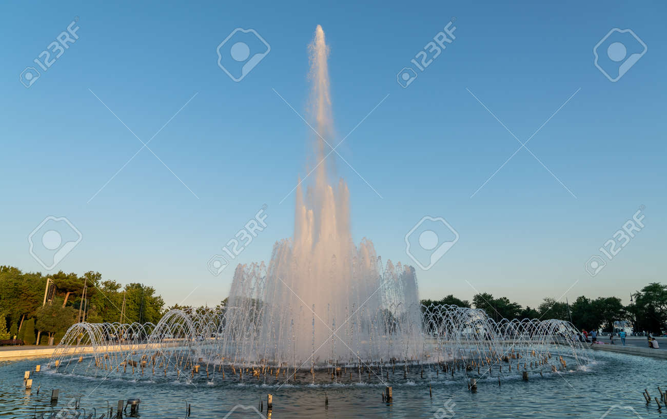 Baku, Azerbaijan - July 2019: Fountain in Baku National Seaside Park in front of the parliament building in the evening - 164356026 Baku, Azerbaijan - July 2019: Fountain in Baku National Seaside Park in front of the parliament building in the evening - 164356026