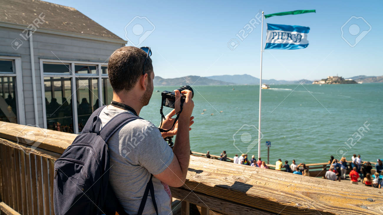 San Francisco, California, USA - August 2019: Man taking photos of Alcatraz Iceland standing in Pier 39 the fisherman's wharf - 164356015 San Francisco, California, USA - August 2019: Man taking photos of Alcatraz Iceland standing in Pier 39 the fisherman's wharf - 164356015