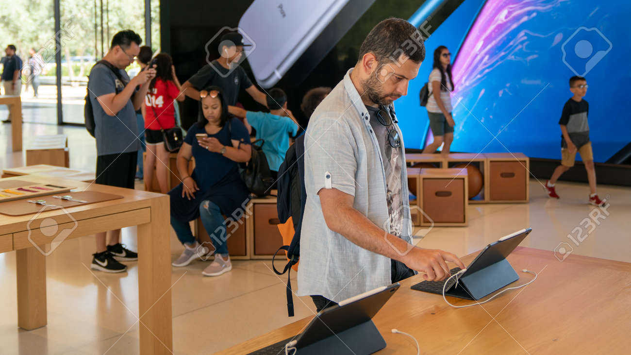 Cupertino, CA, USA - August 2019: Man examining an iPad in Apple Store in Cupertino, Apple Headquarters infinite loop - 164356008 Cupertino, CA, USA - August 2019: Man examining an iPad in Apple Store in Cupertino, Apple Headquarters infinite loop - 164356008