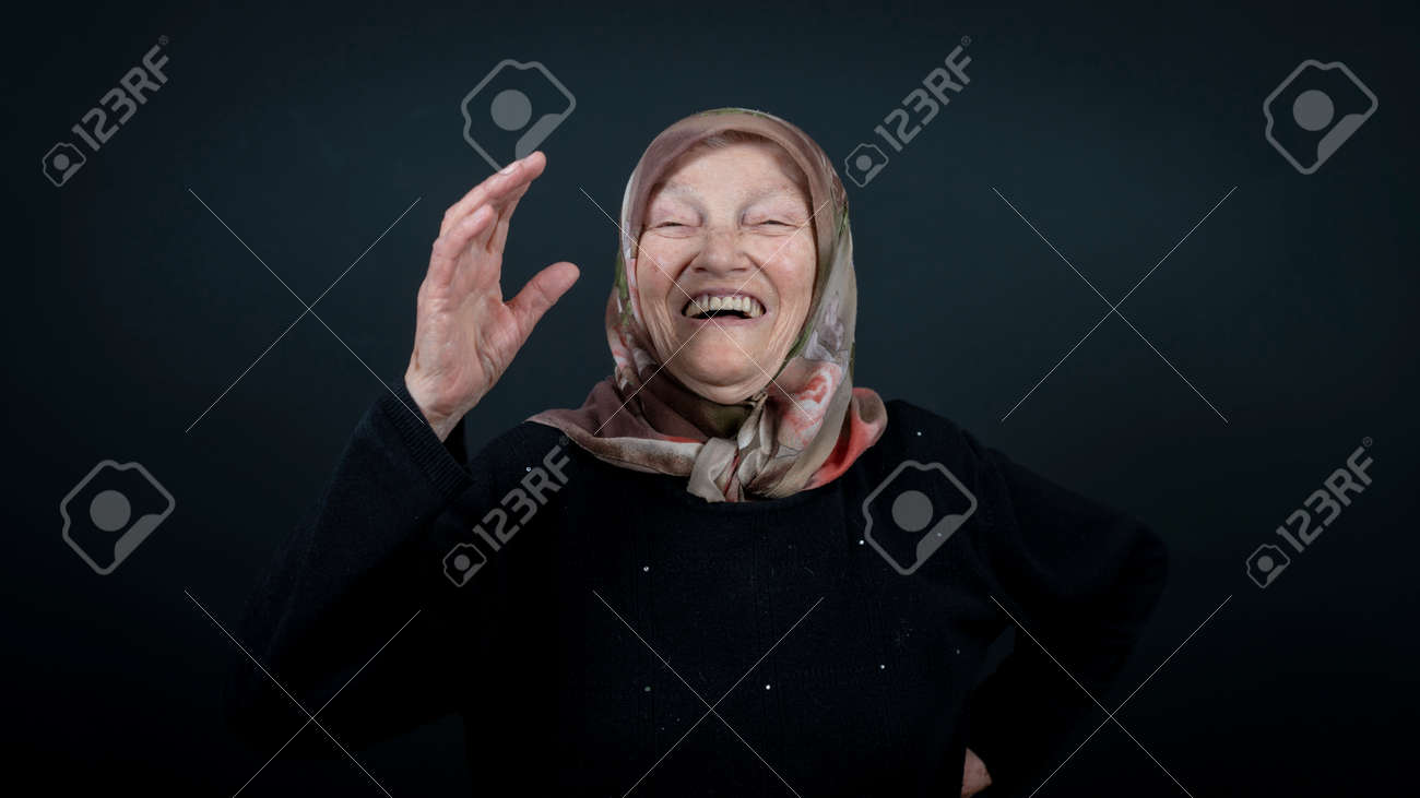 Portrait of a Turkish senior muslim woman with black background. She is very happy and laughing. - 172150636 Portrait of a Turkish senior muslim woman with black background. She is very happy and laughing. - 172150636