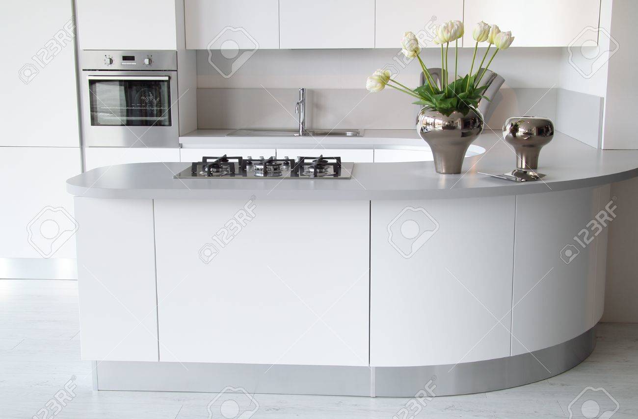 Cuisine moderne blanche avec four fermé. Élégant et élégant décoration de fleurs Cuisine moderne blanche avec four fermé. Élégant et élégant décoration de fleurs