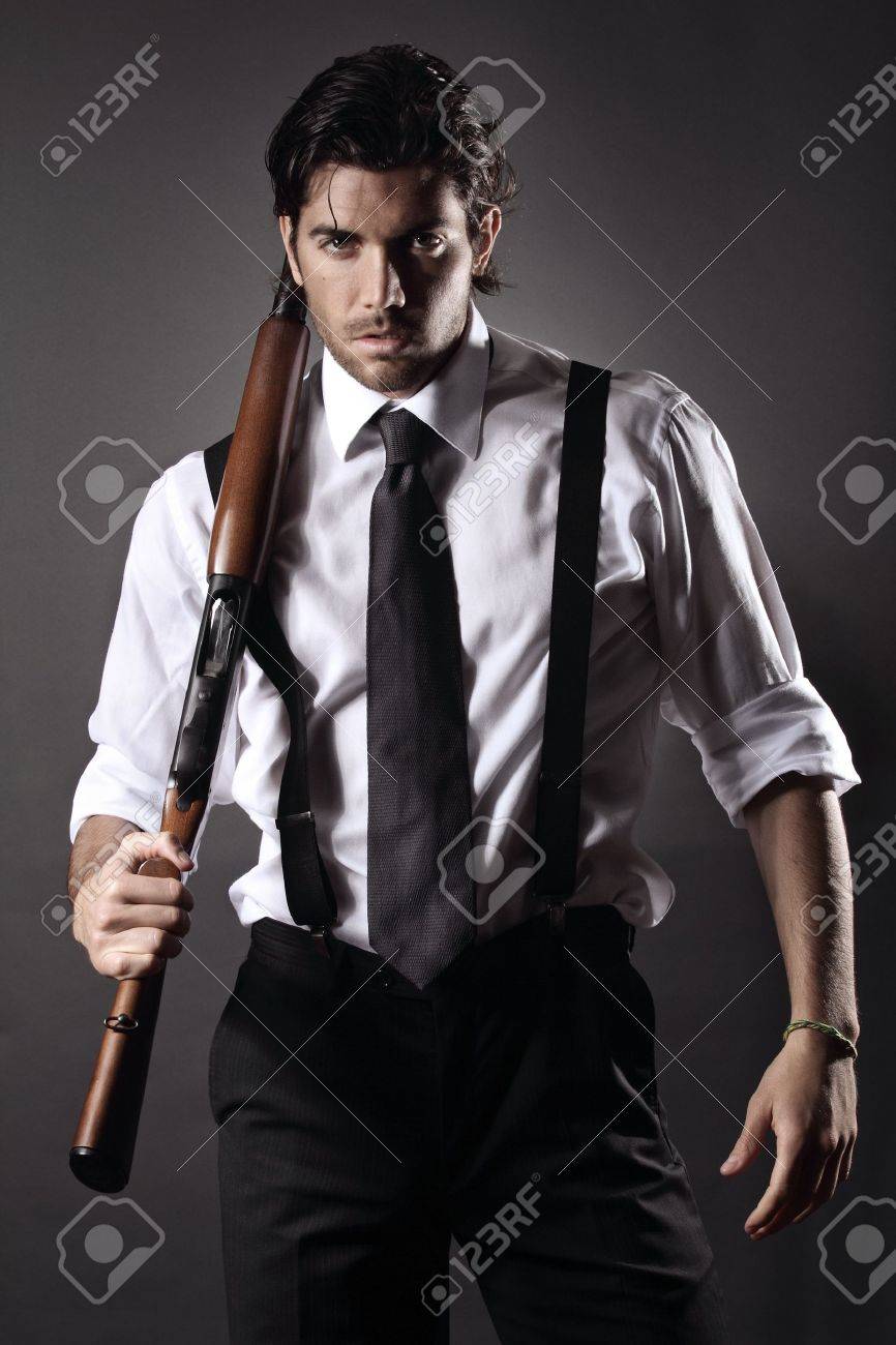 very attractive fashion model dressed like a gangster with shotgun