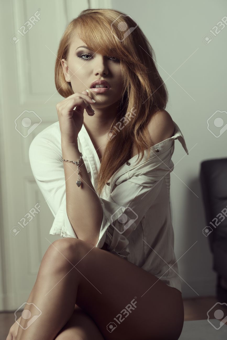 Provocativa Mujer Joven Vestida Sólo Con La Camisa Abierta Posando Con Las  Piernas Desnudas Y Hombro En Pose Erótica Fotos, retratos, imágenes y  fotografía de archivo libres de derecho. Image 32431210