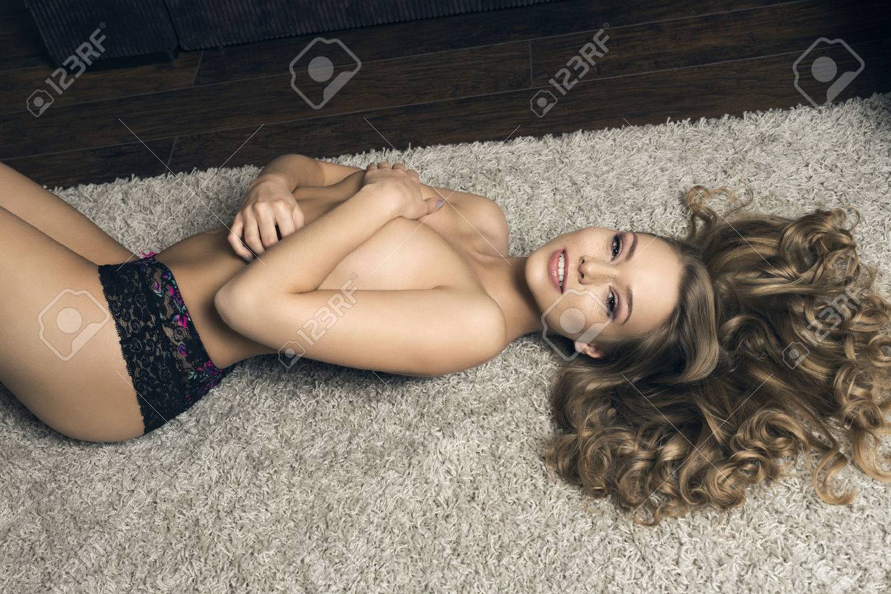 Sexy Woman With Wavy Blonde Hair And Freckles Lying On Carpet Sexy Woman With Wavy Blonde Hair And Freckles Lying On Carpet