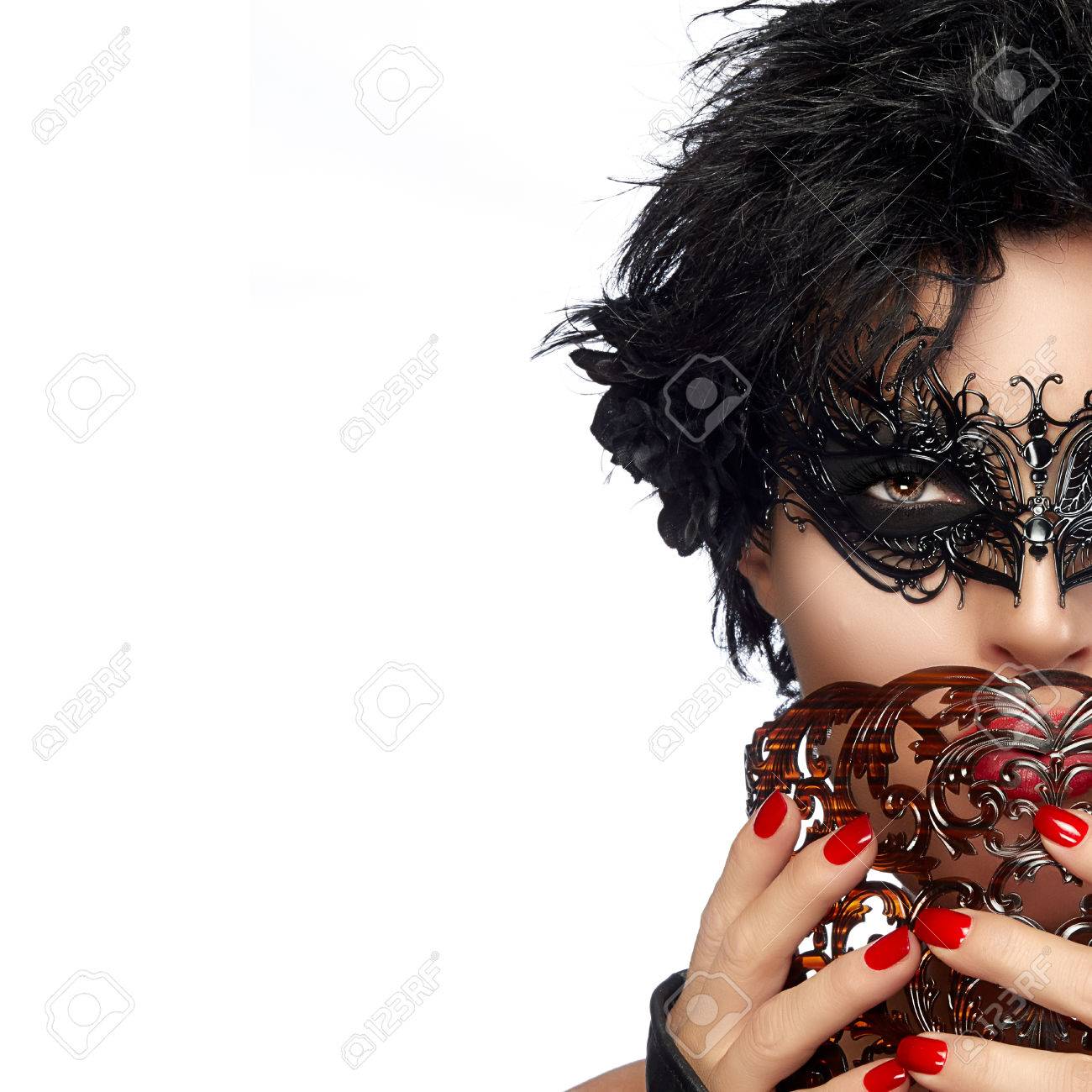 ファッション性の高いカメラを見ながら彼女の右耳持株茶色のマスクにエレガントなブラック マスクと黒のバラの花を着て美しい女性の半分の顔の肖像画 美しさとメイクアップのコンセプトです コピー スペースと白い背景で隔離 の写真素材 画像素材 Image
