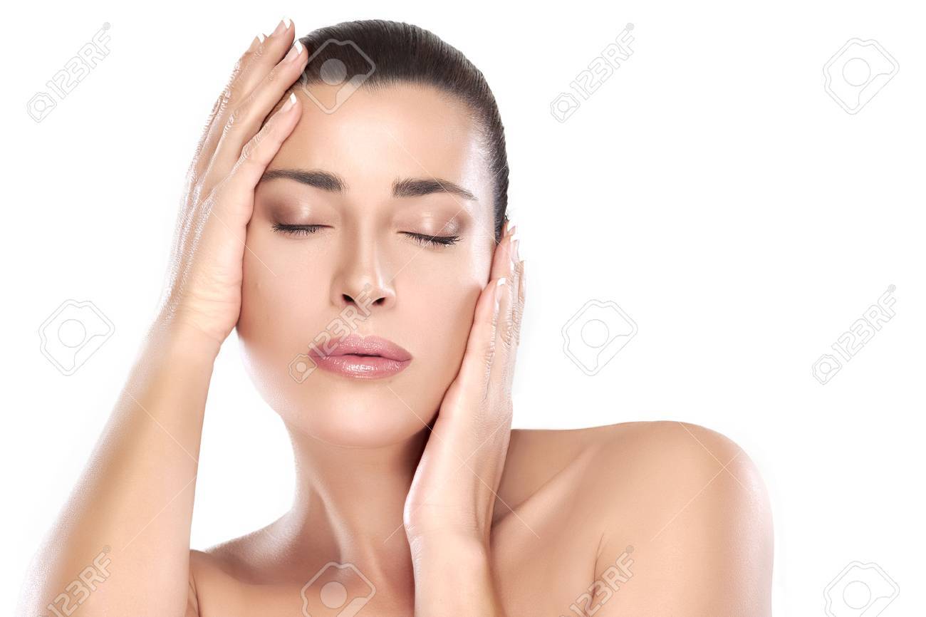 Beautiful young woman with hands on face and closed eyes with a serene expression suitable for skincare and spa concepts. Perfect skin. Portrait isolated on white with copy space for text. - 50754593 Beautiful young woman with hands on face and closed eyes with a serene expression suitable for skincare and spa concepts. Perfect skin. Portrait isolated on white with copy space for text. - 50754593