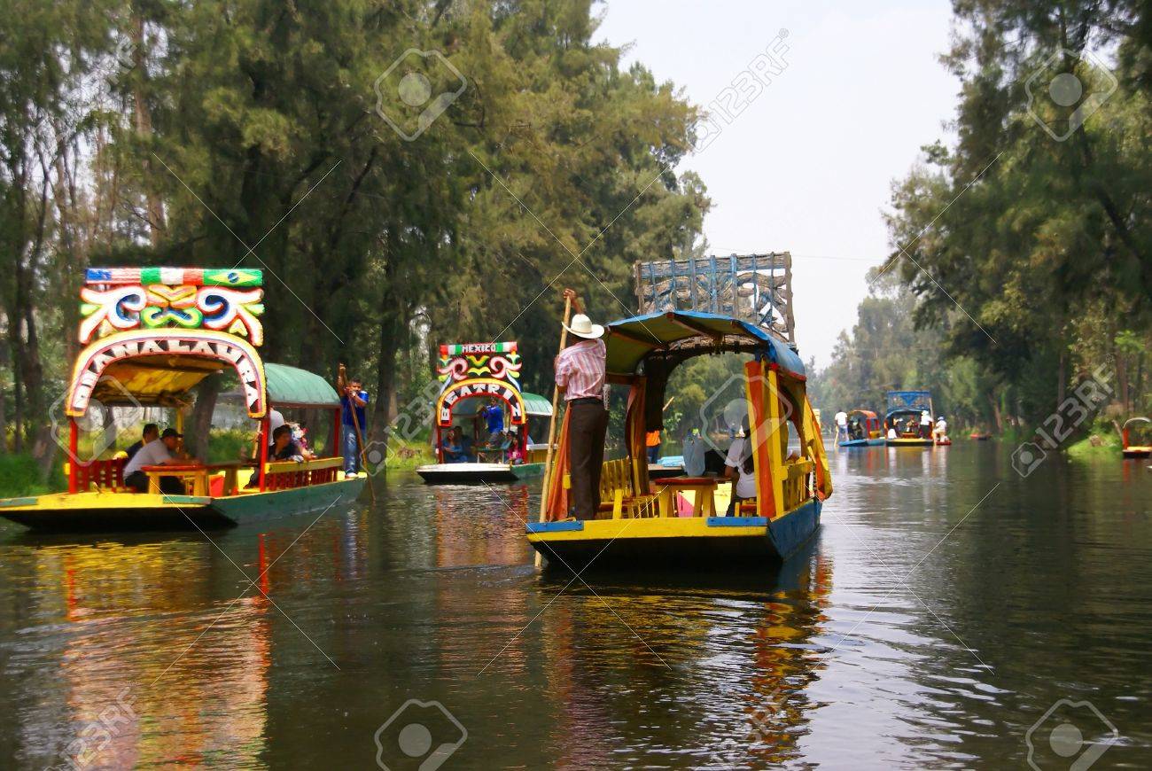 Xochimilco Mexico City 3 SEP 2008 - Boatman poling brightly colored boat, Xochimilco canals, floating gardens, Mexico City - 11458445 Xochimilco Mexico City 3 SEP 2008 - Boatman poling brightly colored boat, Xochimilco canals, floating gardens, Mexico City - 11458445