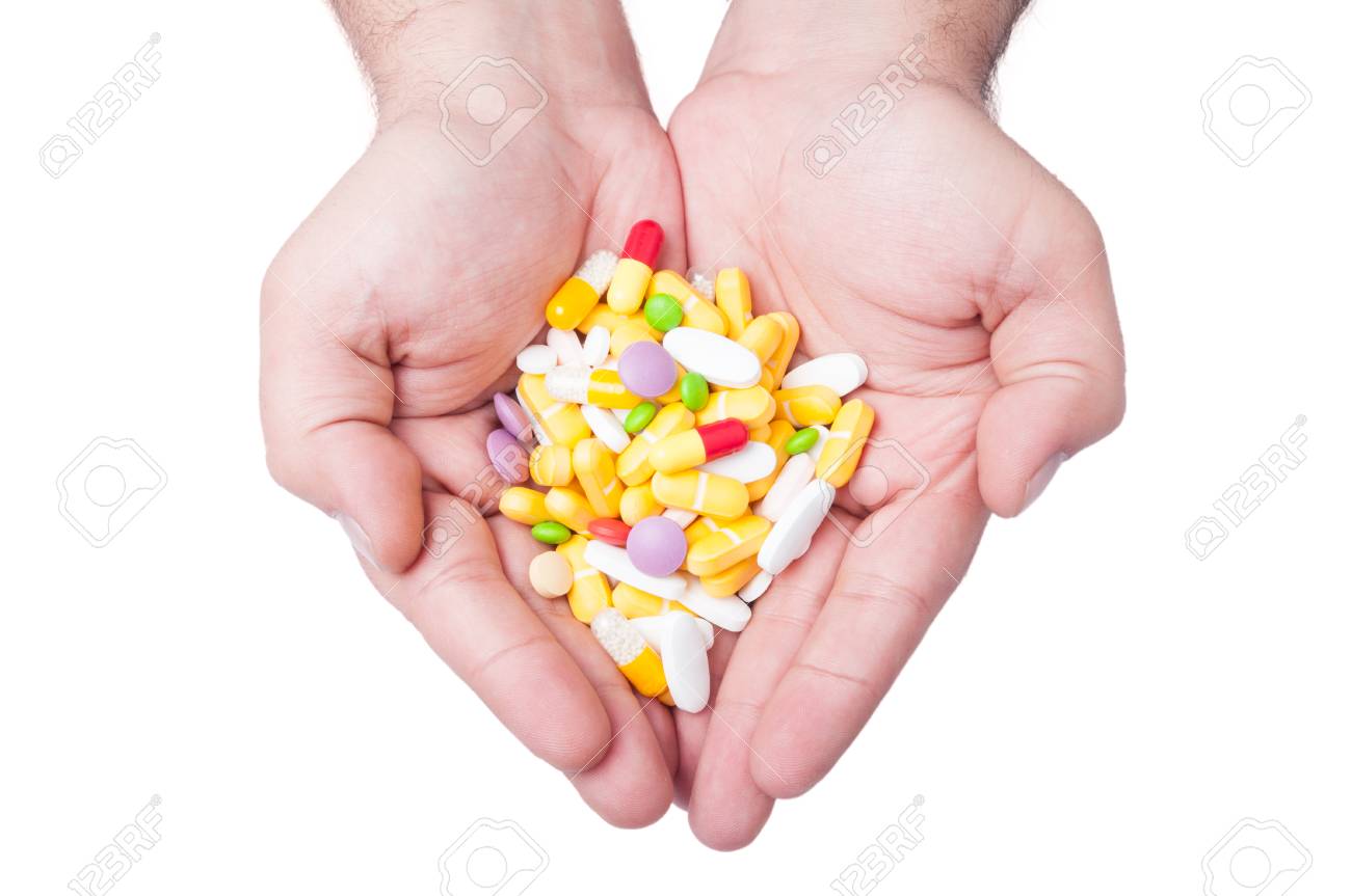 A man is holding a lot of different pills in both his hands - 35478108 A man is holding a lot of different pills in both his hands - 35478108