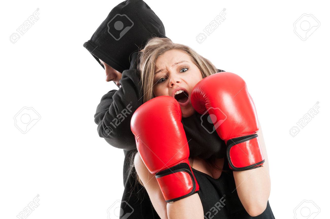 male aggressor grabbing a frightened woman wearing boxing gloves