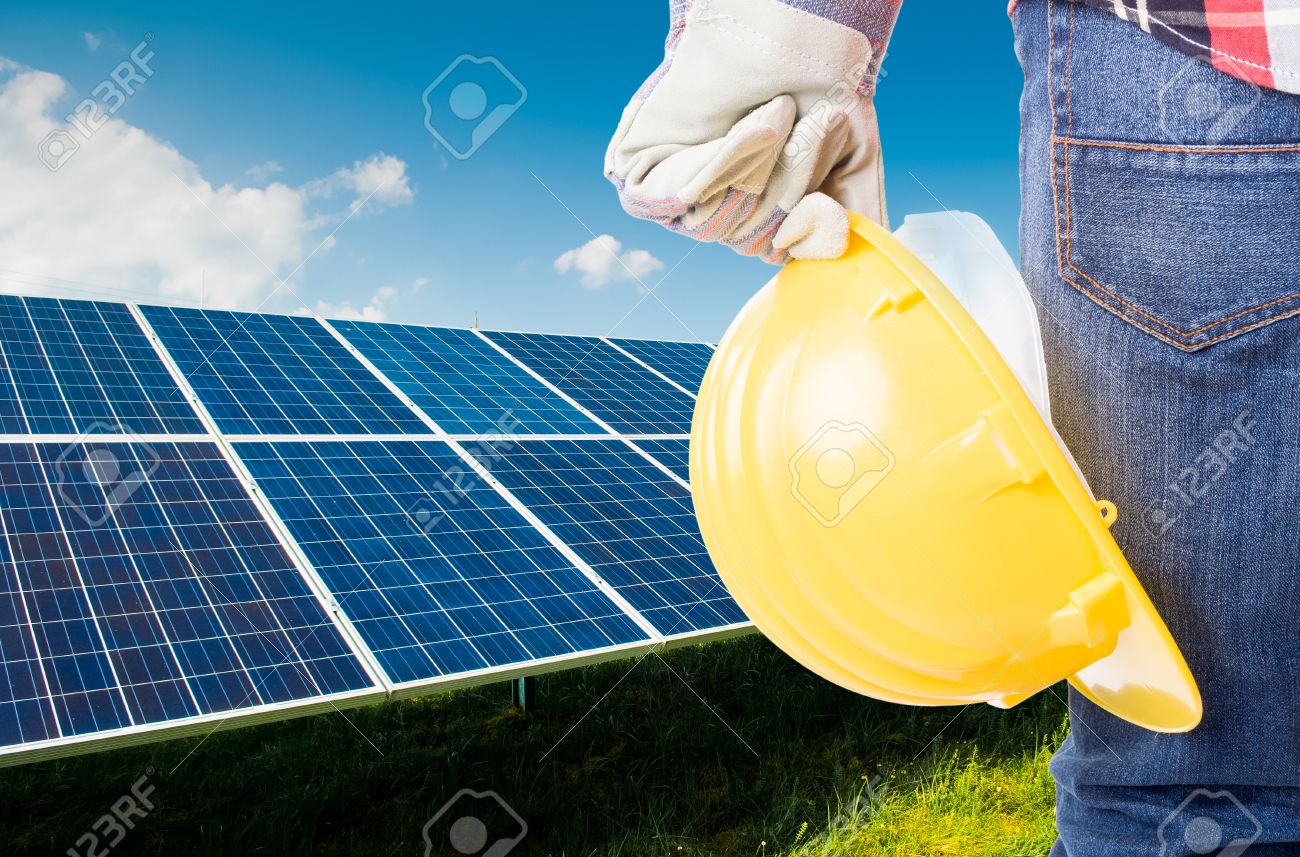 Engineer holding yellow construction helmet on solar power panels background - 43003658 Engineer holding yellow construction helmet on solar power panels background - 43003658