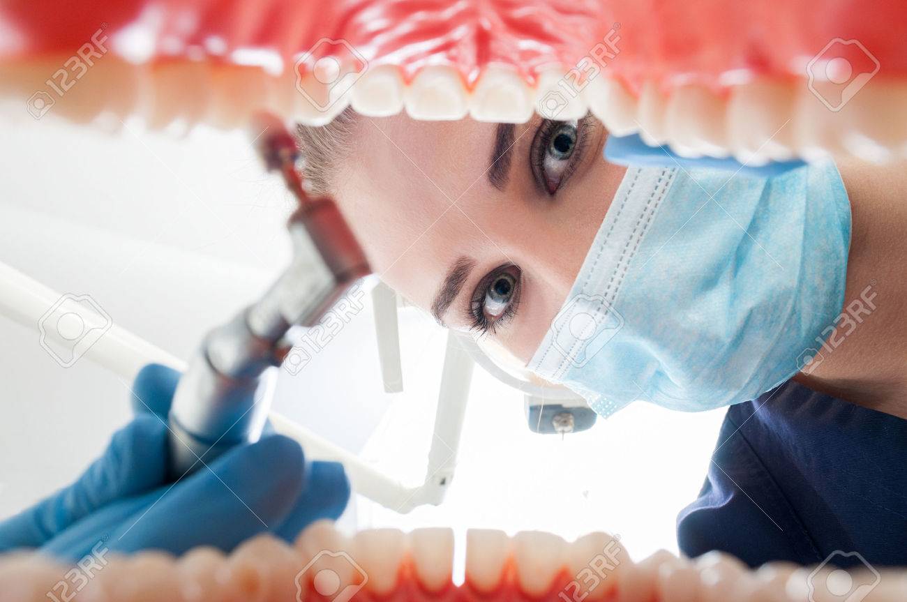 Close-up of young dentist examine patient's open mouth with dental tool to prevent caries in dental office - 53141540 Close-up of young dentist examine patient's open mouth with dental tool to prevent caries in dental office - 53141540