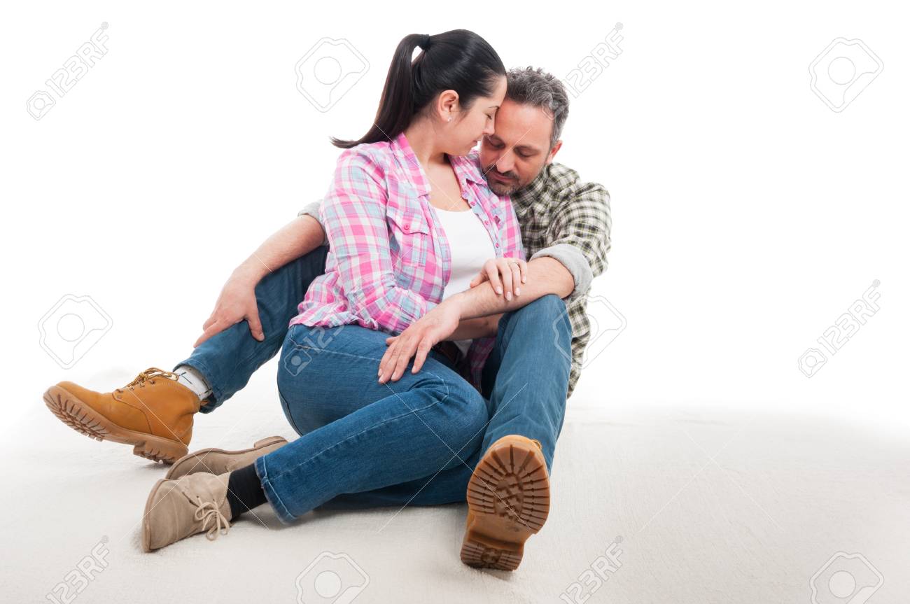 床と白で隔離を受け入れ一緒に愛情のこもったカップル座っています の写真素材 画像素材 Image