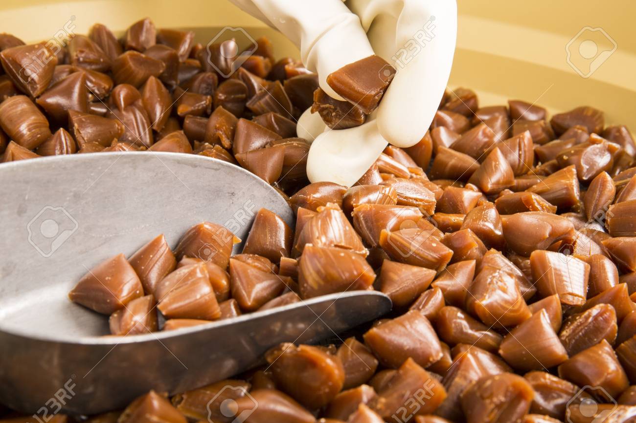 キャラメル キャラメルお菓子バター スコッチ キャンデーの職人の生産 白い手袋 揺れ 女性が瓶に入れて 水差しバターの部分でキャンディーズ フランスの伝統的なお菓子 の写真素材 画像素材 Image