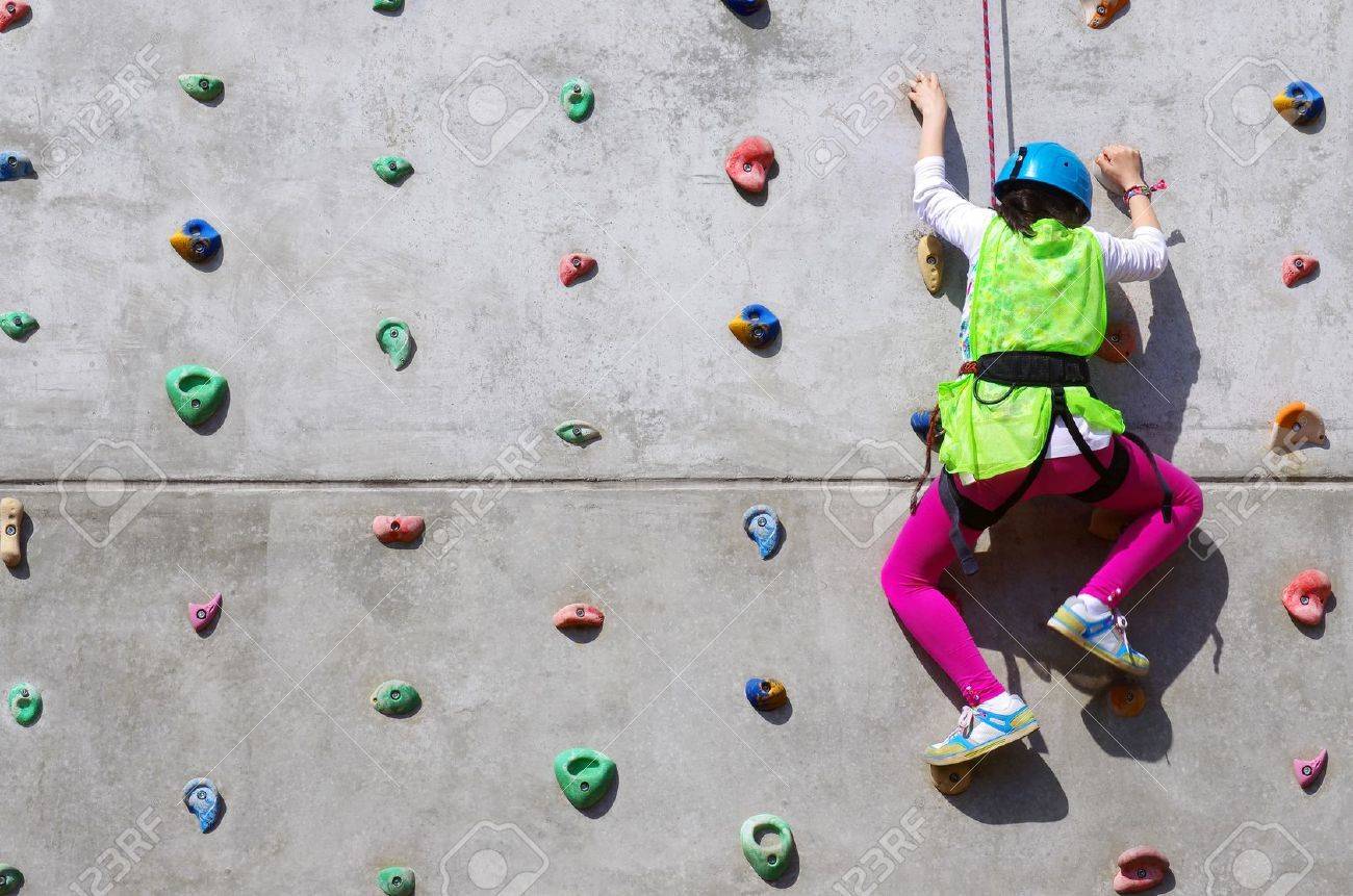 youngsters effort in climbing a wall to reach the top stock photo wall climbing