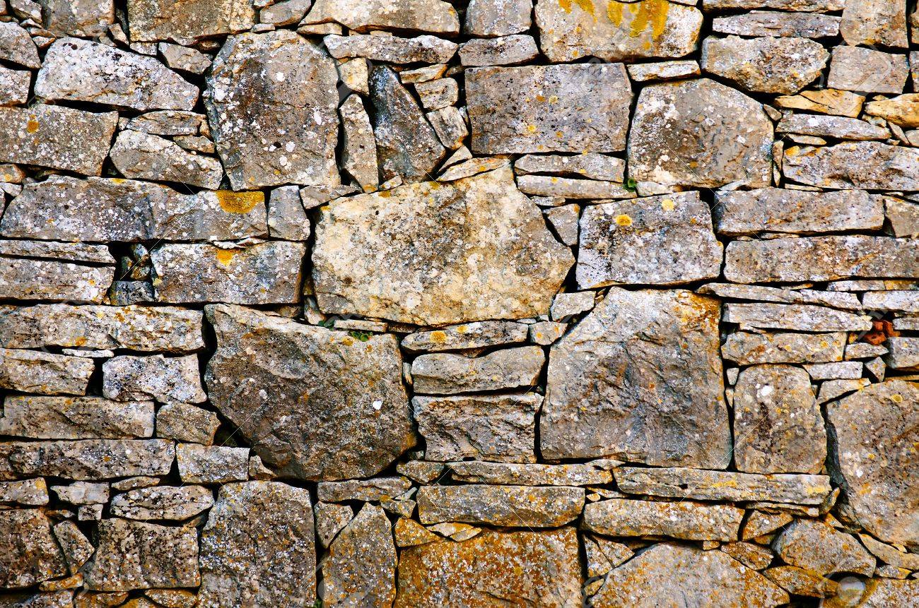 background detail of a old rustic stone wall stock photo picture