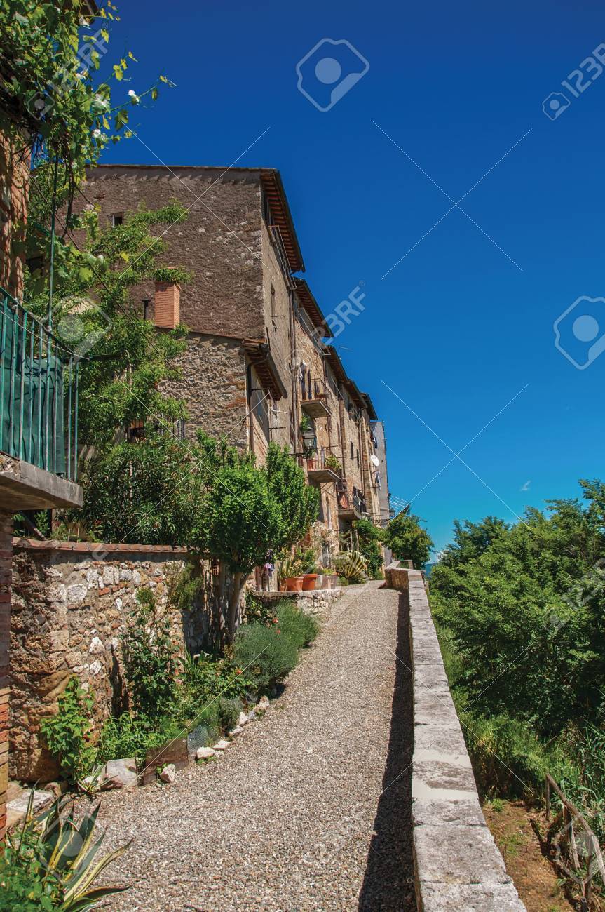 ストリート ビューには 小石の通路 草花や町のコッレ ディ ヴァル デルサの晴れた青空 保存の歴史的な中心の優雅な村 トスカーナ地方に位置します の写真素材 画像素材 Image