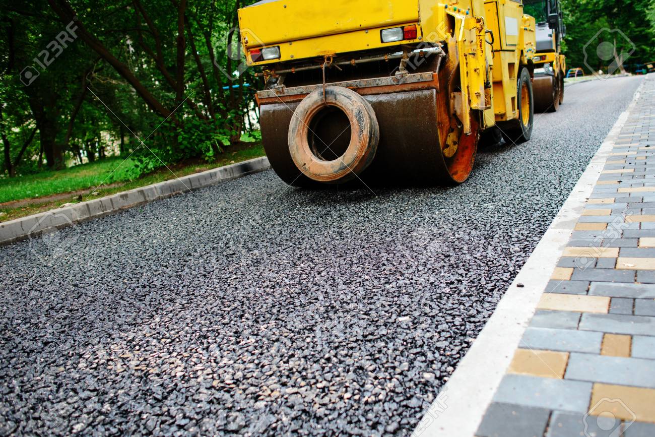Carrying out repair works: asphalt roller stacking and pressing hot lay of asphalt. Machine repairing road. - 85040870 Carrying out repair works: asphalt roller stacking and pressing hot lay of asphalt. Machine repairing road. - 85040870