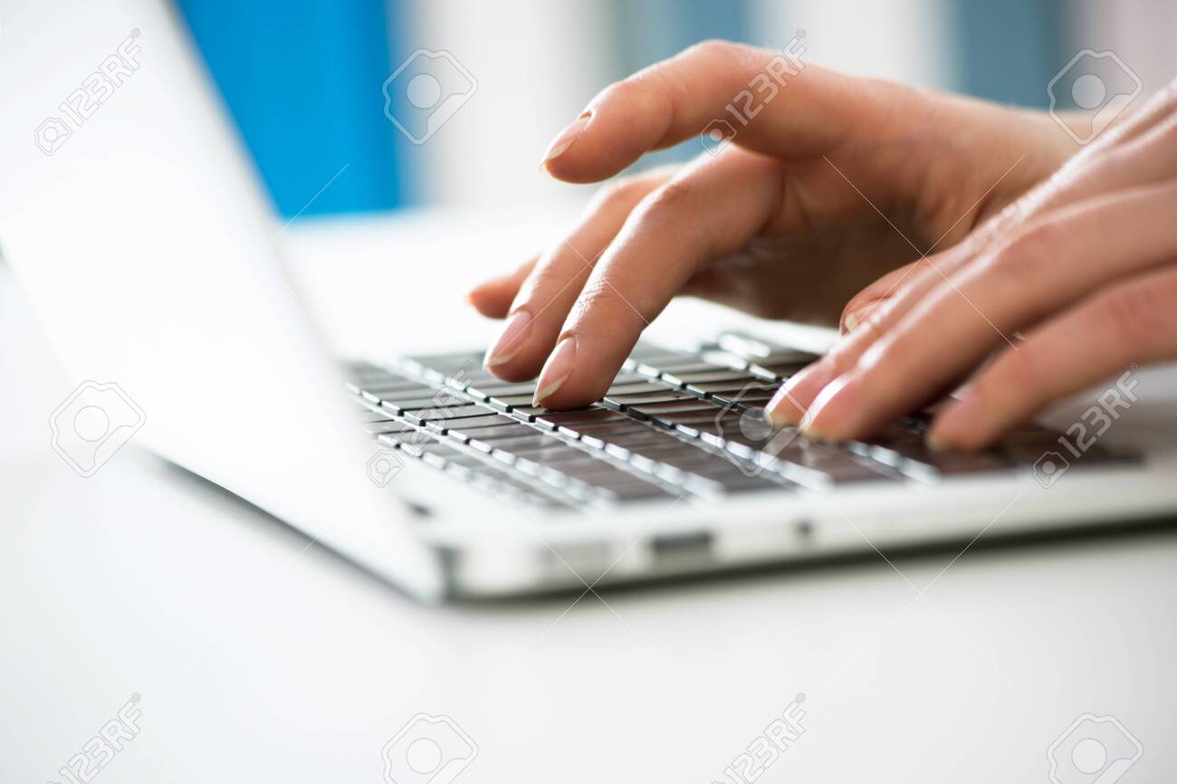 Close-up of hands of businesswoman typing on a laptop. View through blinds - 120595171 Close-up of hands of businesswoman typing on a laptop. View through blinds - 120595171