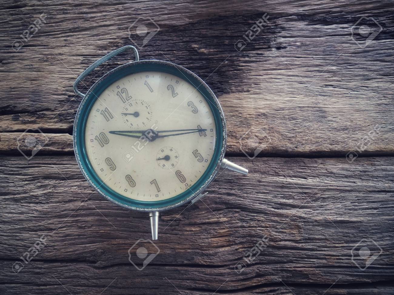 old winding clock on wooden board in vintage color schemes with