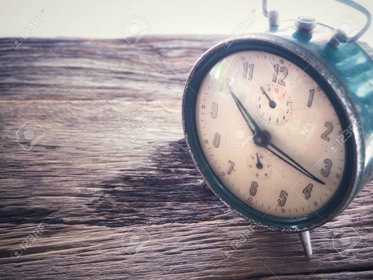 old winding clock on wooden board in vintage color schemes with