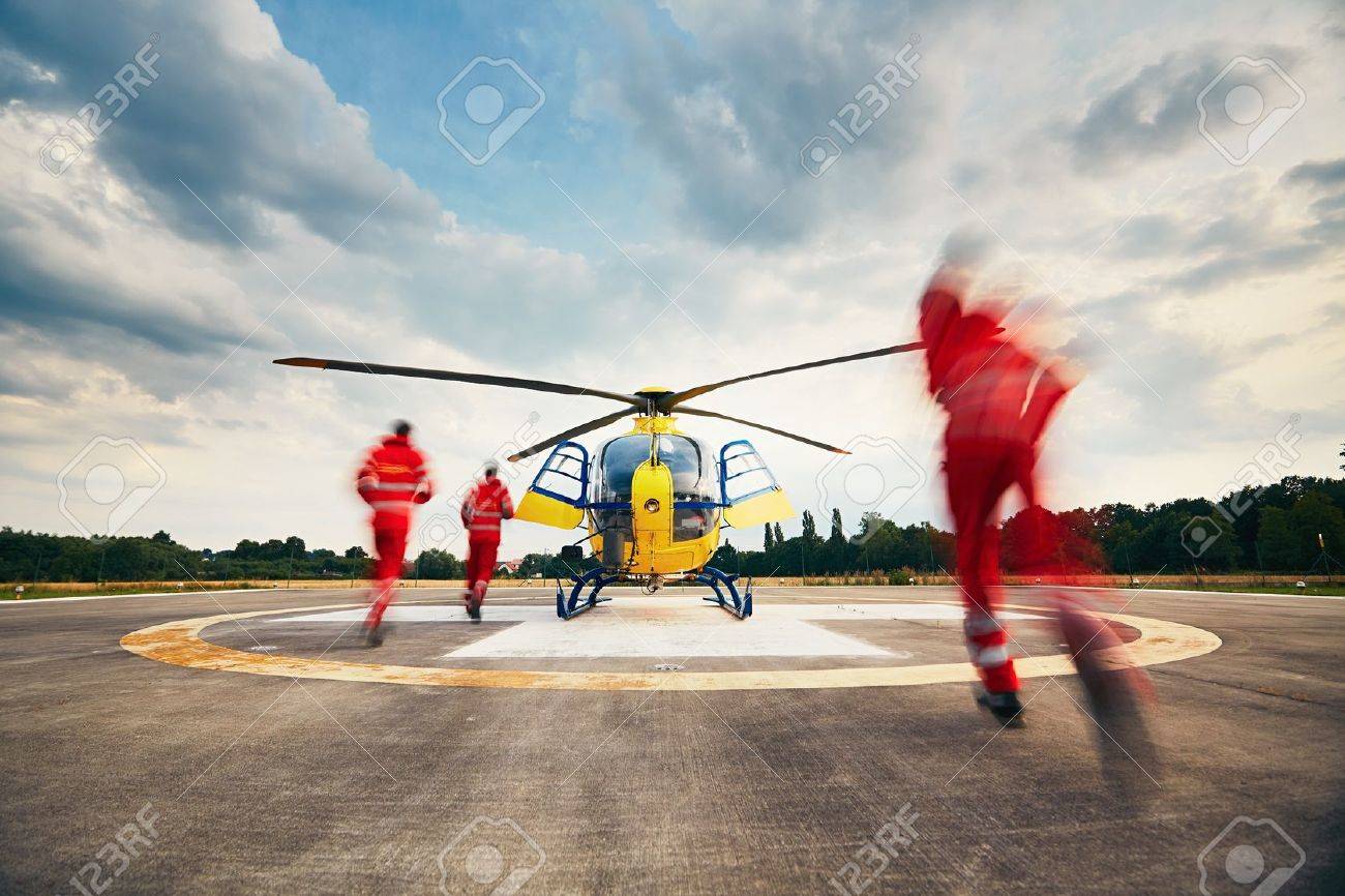 Alarm for the air rescue service. Team of rescuers (paramedic, doctor and pilot) running to the helicopter on the heliport. - 60863543 Alarm for the air rescue service. Team of rescuers (paramedic, doctor and pilot) running to the helicopter on the heliport. - 60863543