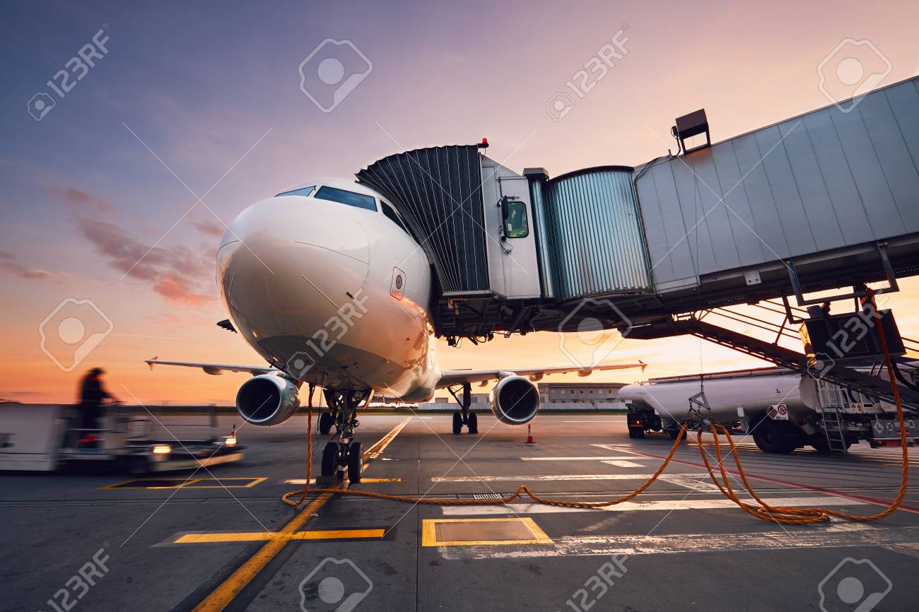 Busy airport at the colorful sunset. Preparation of the airplane before flight. - 88995484 Busy airport at the colorful sunset. Preparation of the airplane before flight. - 88995484