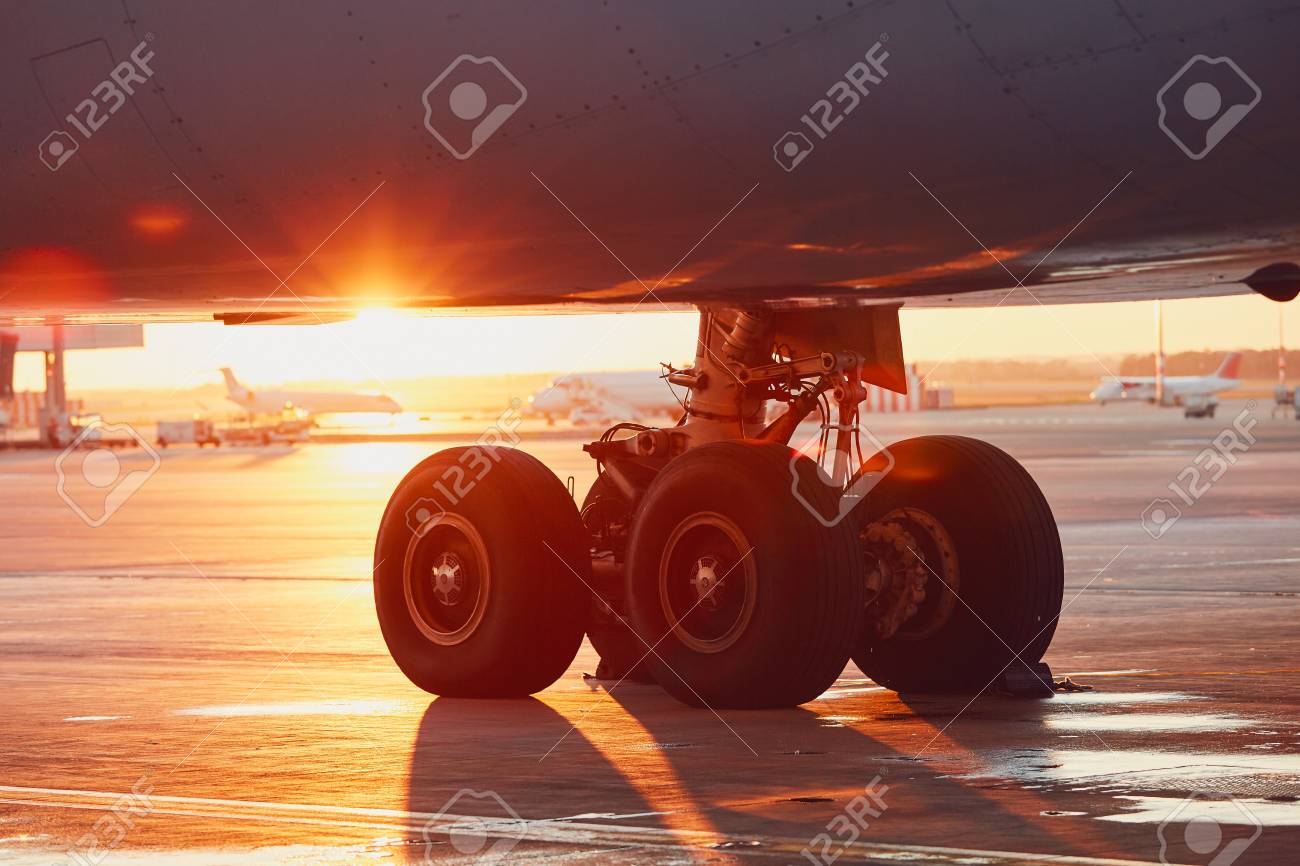 Landing gear of the airplane. Amazing sunset at the airport. - 92187784 Landing gear of the airplane. Amazing sunset at the airport. - 92187784