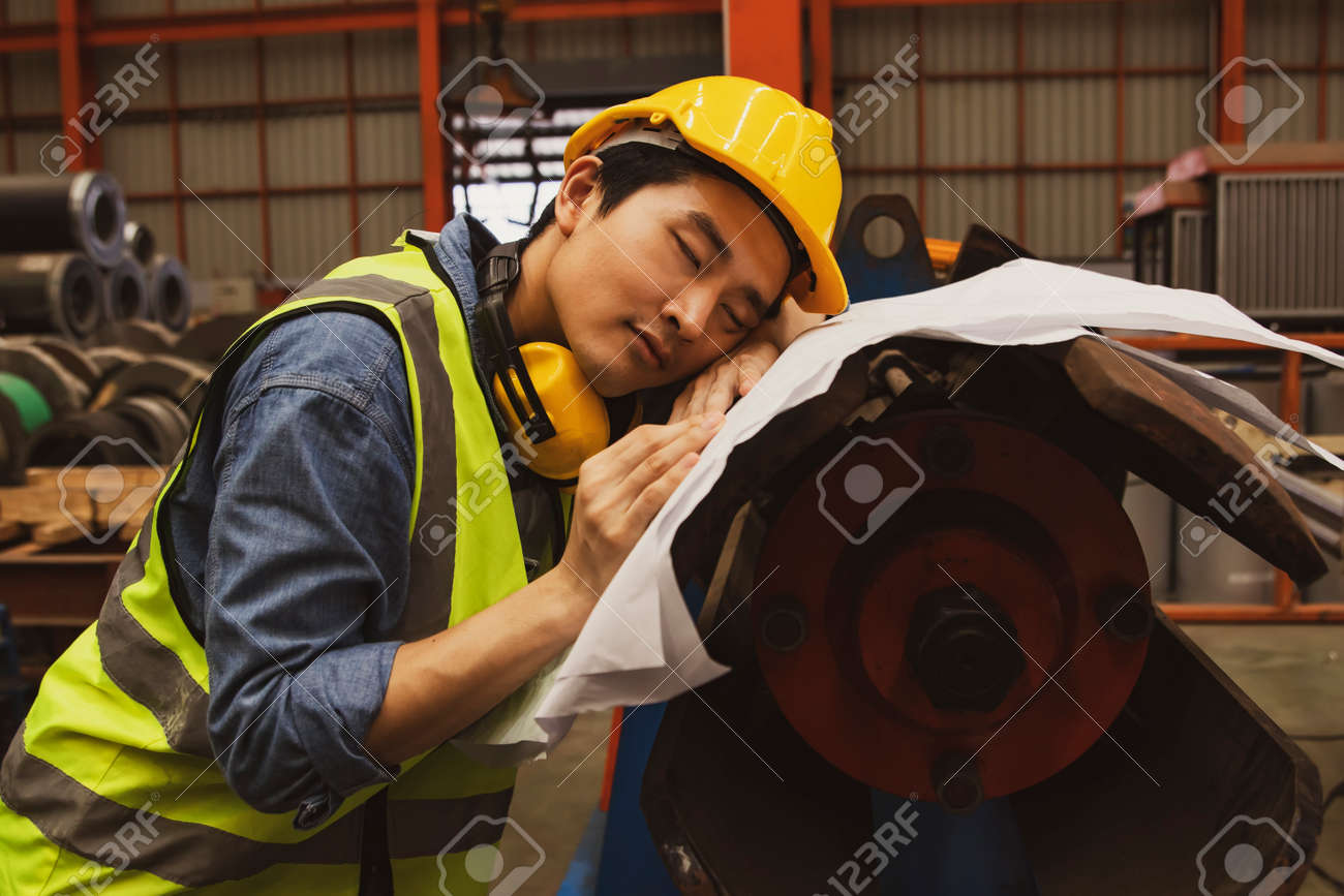 Trabalhador Do Sexo Masculino Asiático Bisbilhotando Em Plantas Em Risco De  Acidente E Perigo Área De Trabalho De Máquinas: Trabalhador Do Sexo  Masculino Dorme Cansado Por Causa De Pouco Descanso E Muito