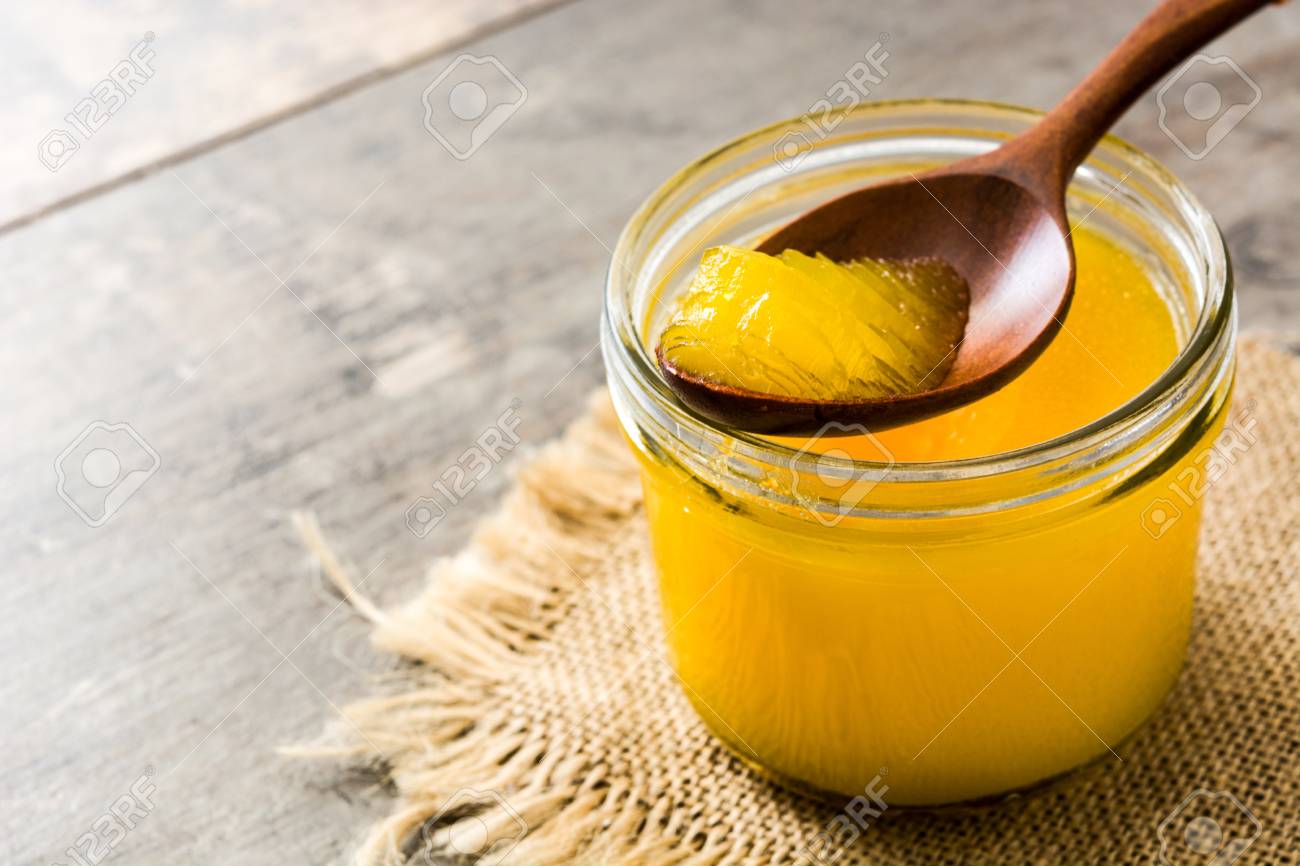 Ghee Or Clarified Butter In Jar And Wooden Spoon On Wooden Table ...