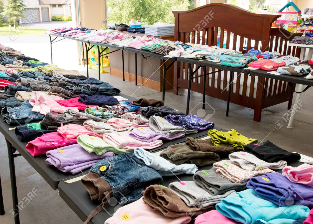 Tables of clothing and baby goods at suburban garage sale - 85058108 Tables of clothing and baby goods at suburban garage sale - 85058108