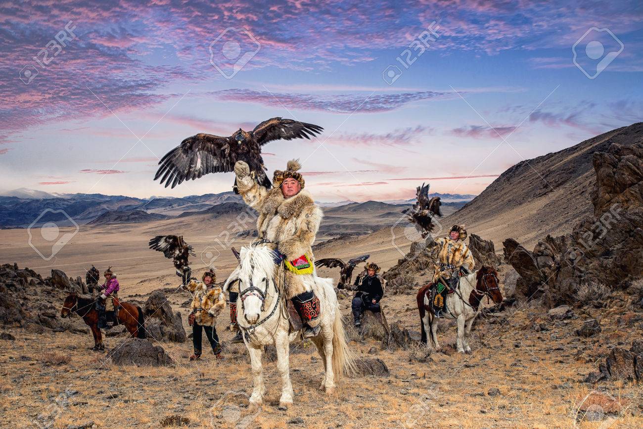 Kazakh Eagle Hunter In Traditionally Trained Golden Eagles Riding