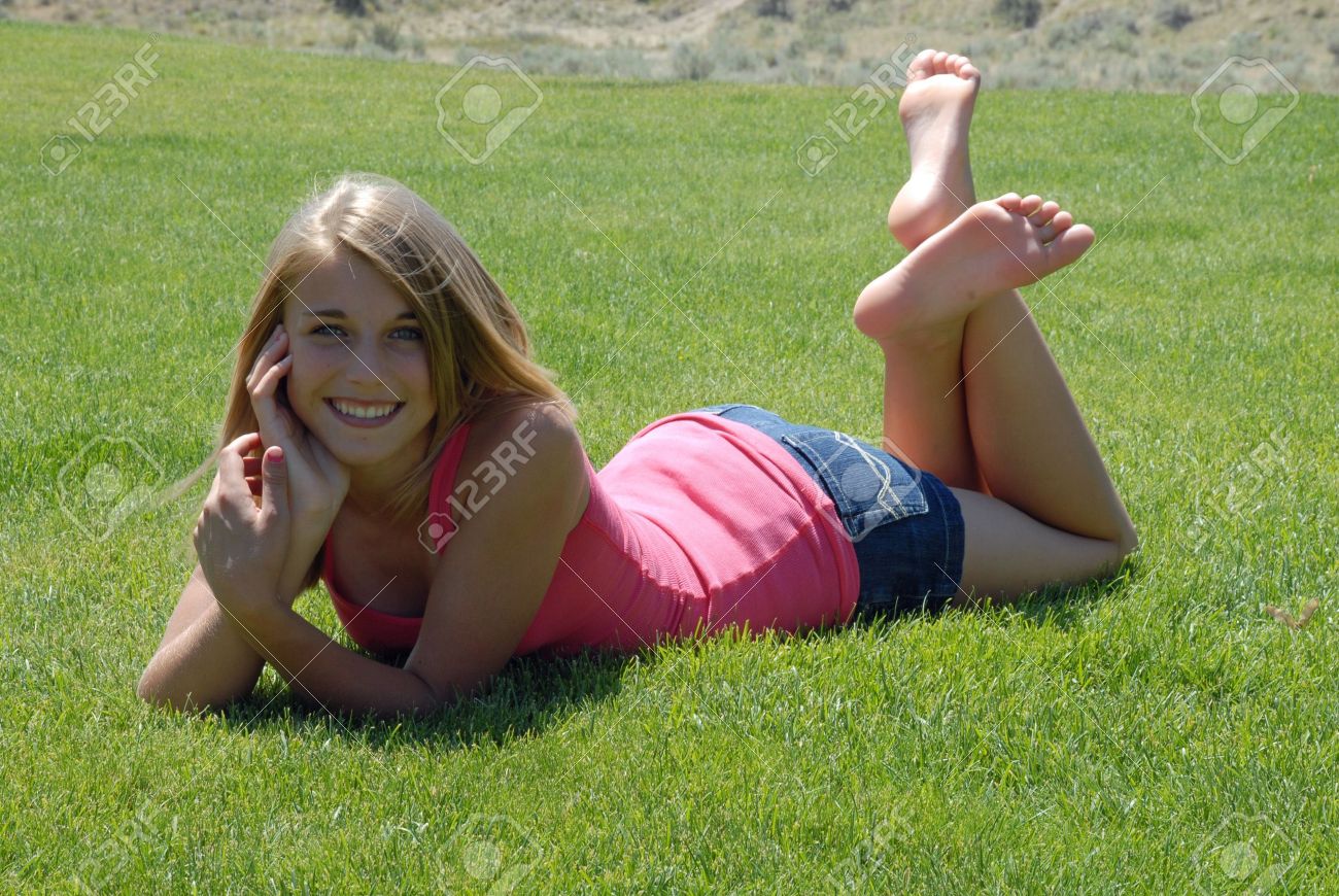 young girl laying on green lawn stock photo picture and royalty