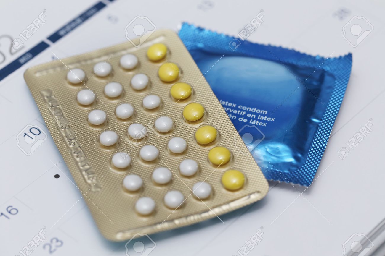 birth control pills and condom on a calendar stock photo picture pill calendar