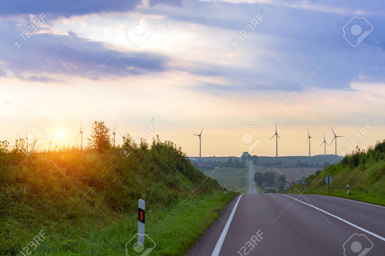 風車は 田畑や農地にブレードを回転させます 電気風力発電機は 環境発電します 舗装された高速道路の高さからの眺め早朝霧 Taurage リトアニア ヨーロッパ の写真素材 画像素材 Image