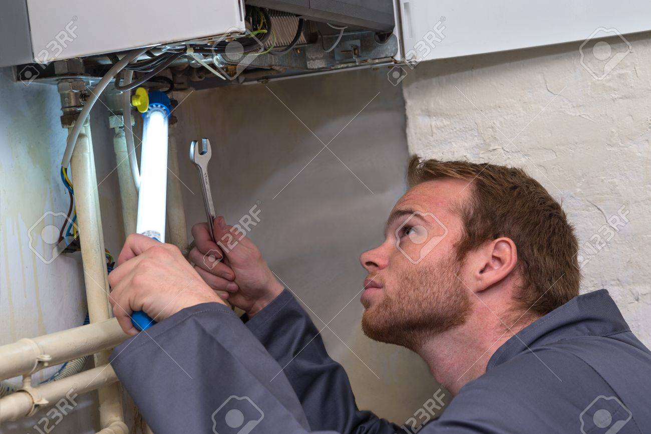 Engineer controlling the heating pipes at the boiler room - 50347483 Engineer controlling the heating pipes at the boiler room - 50347483