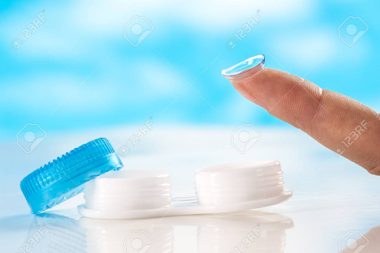 close up Contact lens on finger tipon blue background - 57106620 close up Contact lens on finger tipon blue background - 57106620
