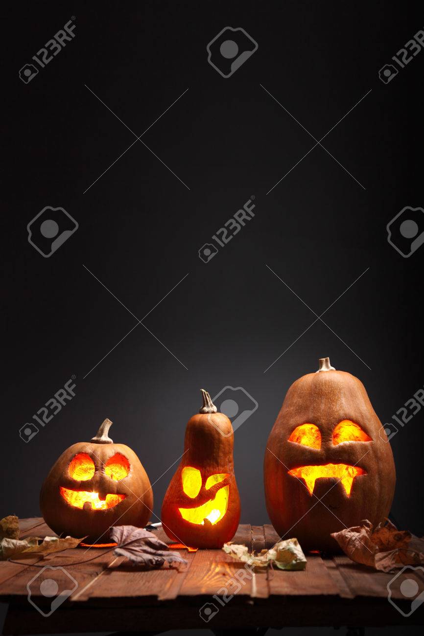 Jack o lanterns Halloween pumpkin face on wooden background and autumn leafs - 45522823 Jack o lanterns Halloween pumpkin face on wooden background and autumn leafs - 45522823