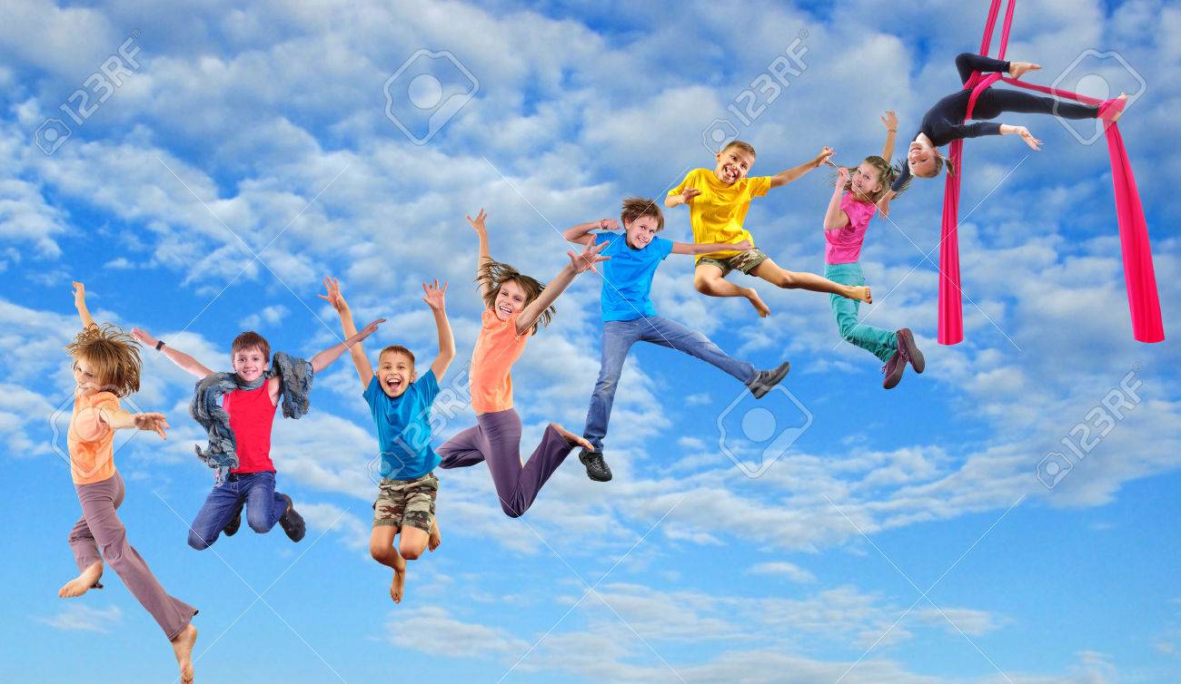 幸せの青い空で一緒に子供たちを実行するジャンプと空中のシルクのダンス グループ 写真のコラージュ 子供の頃 アクティブなライフ スタイル スポーツ 幸福概念 の写真素材 画像素材 Image