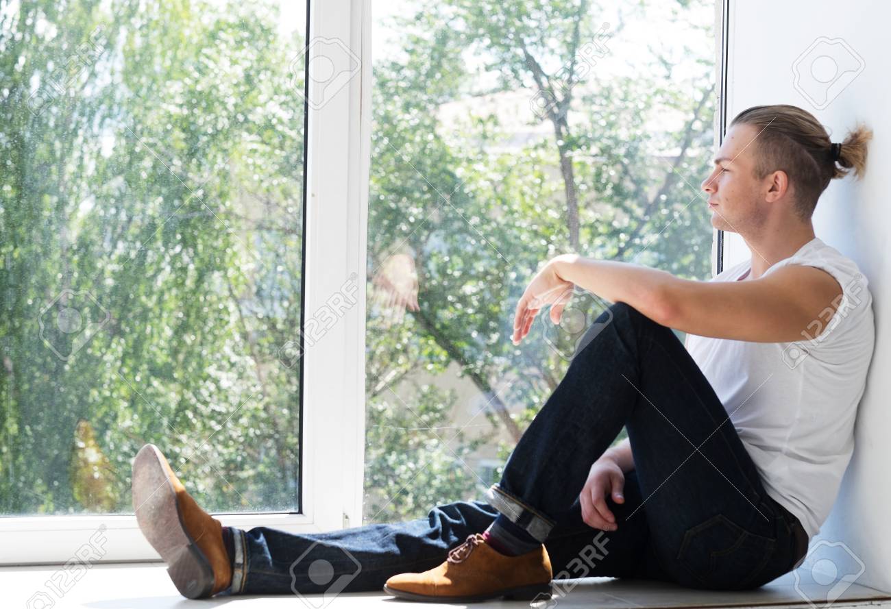 Free Stock Photo of Young Man sitting near window