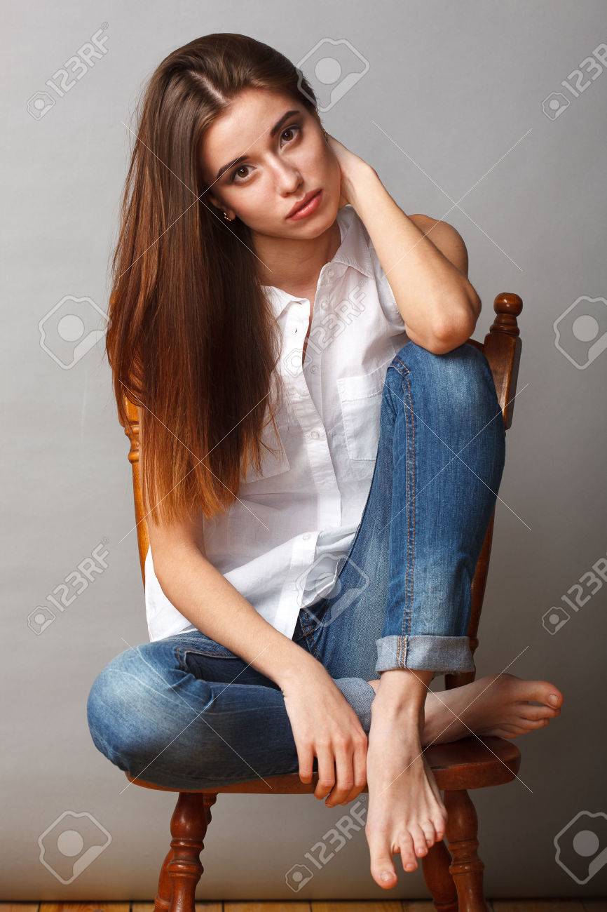 足で椅子に座ってスタジオでポーズ美しいブルネット ファッションモデル の写真素材 画像素材 Image