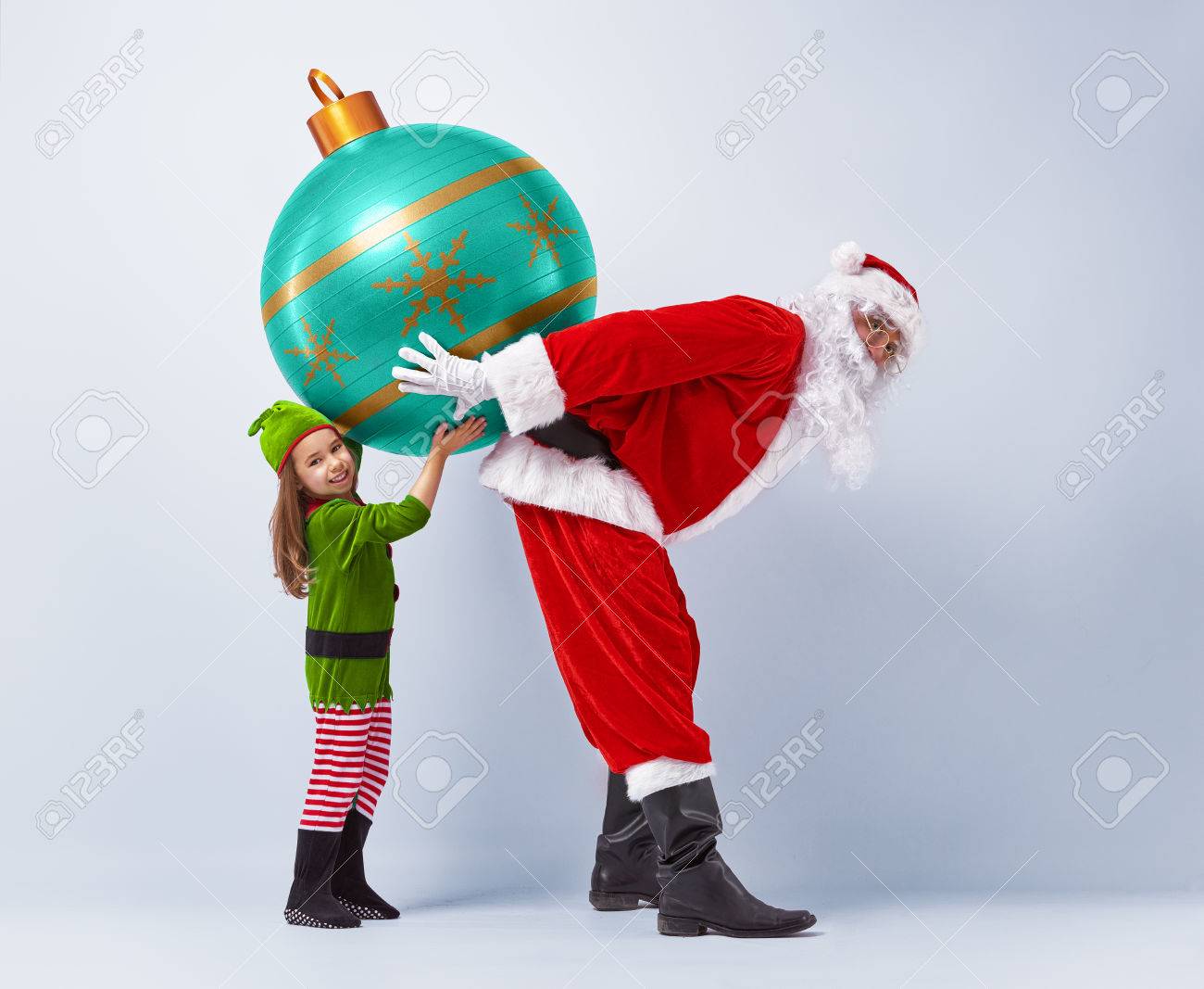 Funny Santa And Elf Holding Together A Huge Christmas Bauble Stock Photo 46636542 Funny Santa And Elf Holding Together A Huge Christmas Bauble Stock Photo 46636542