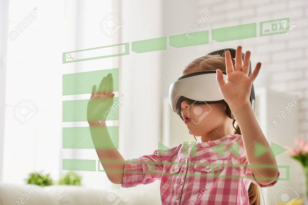 Cute little child girl playing game in virtual reality glasses. - 56412103 Cute little child girl playing game in virtual reality glasses. - 56412103