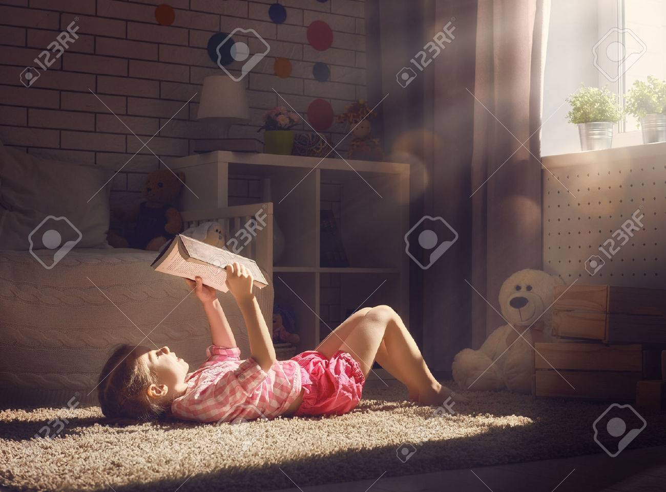 Cute little child girl reading a book. - 56780887 Cute little child girl reading a book. - 56780887