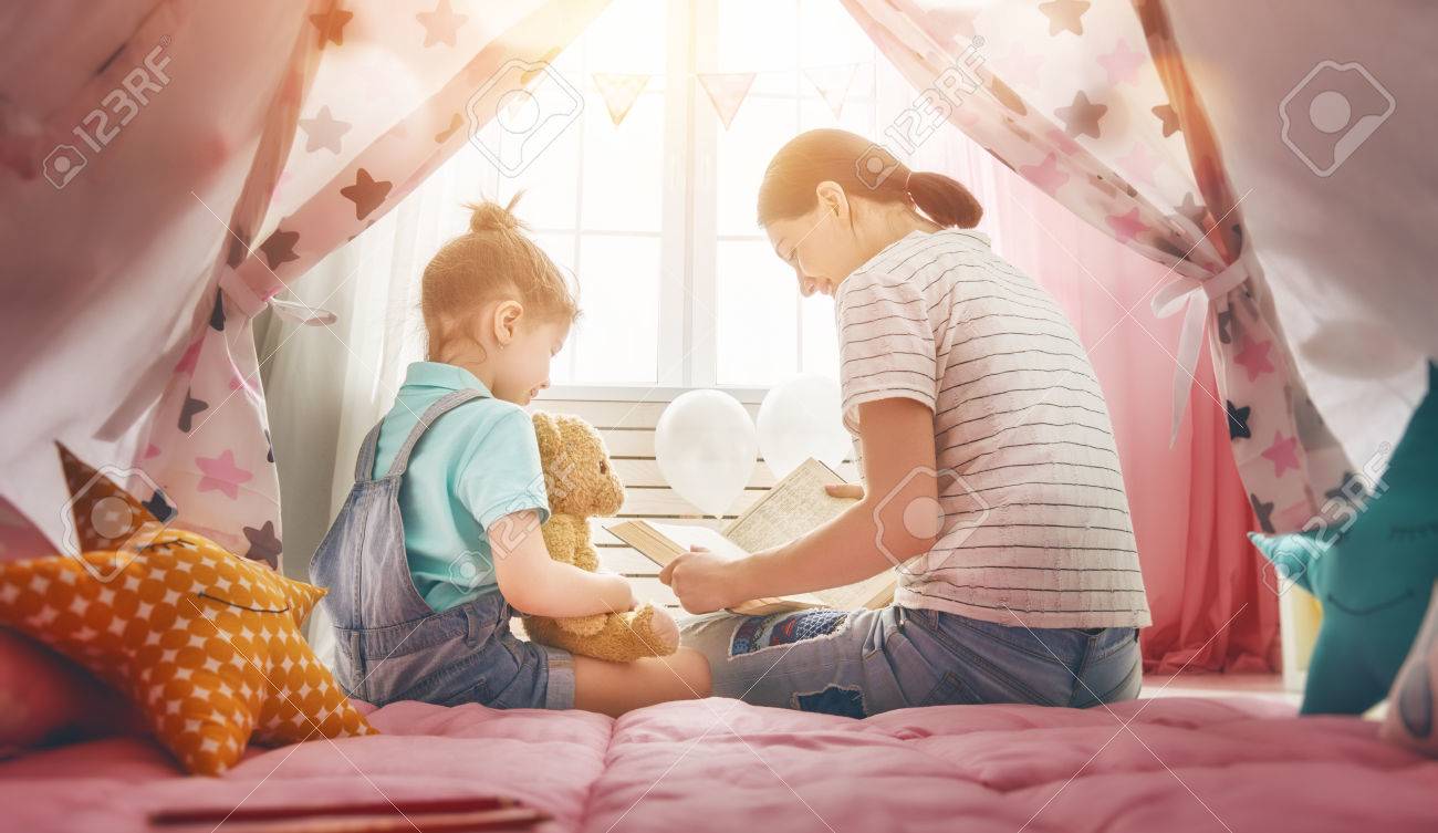 幸せな愛情のある家族 屋内で彼女の娘に本を読んでかなり若い母親 面白いママと子供部屋で楽しく素敵な子 の写真素材 画像素材 Image