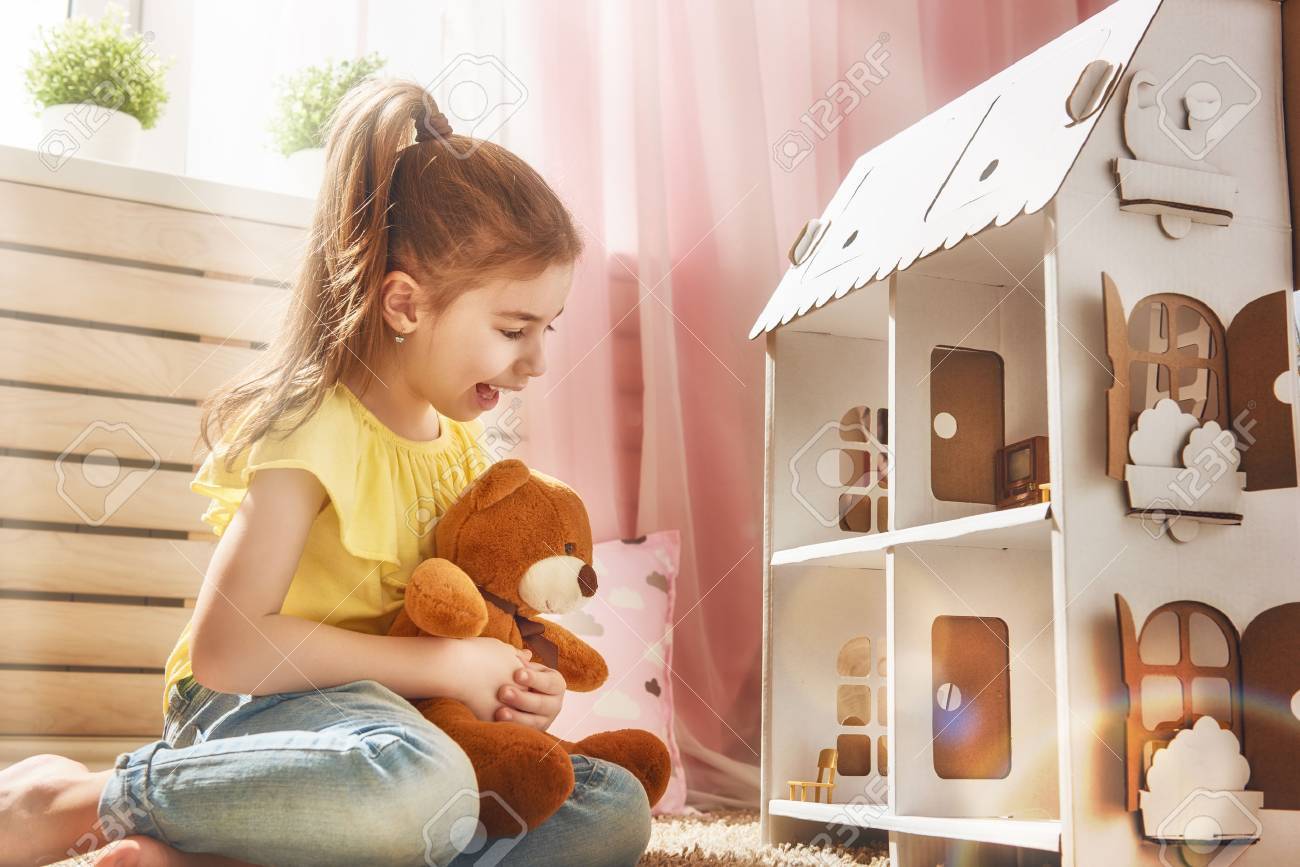 girl playing with dollhouse