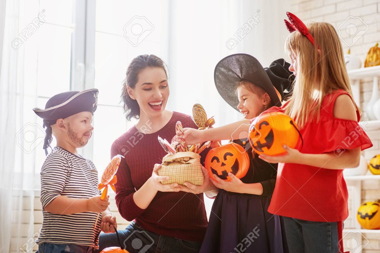 幸せな家族は ハロウィーンを祝う 若いお母さんは お菓子で子供を扱います カーニバルの衣装で面白い子供たち の写真素材 画像素材 Image